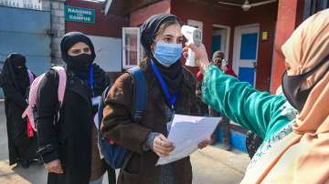 Students undergo thermal testing before entering the school to attend a class.