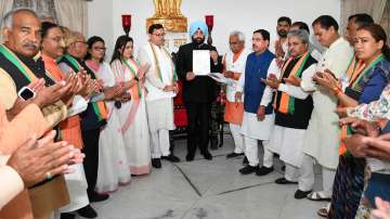 Uttarakhand Governor Gurmeet Singh with state CM-designate Pushkar Singh Dhami and his Cabinet ministers, in Dehradun, Monday, March 21, 2022. 