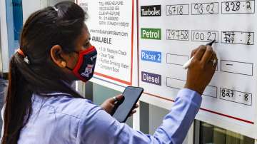 A pump attendant writes the current prices at a fuel station in New Delhi. 