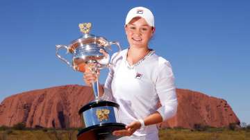 Ashleigh Barty poses with the Daphne Akhurst Memorial Cup as she visits Uluru in the Uluru-Kata Tjut