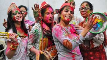 Women celebrate with colours, a day before International Women's Day, in Moradabad, Monday, March 7, 2022.
