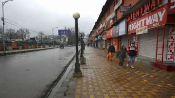 A family walks down a pavement during weekend lockdown imposed by authorities to contain the spread of COVID-19 in Jammu and Kashmir, in Srinagar.