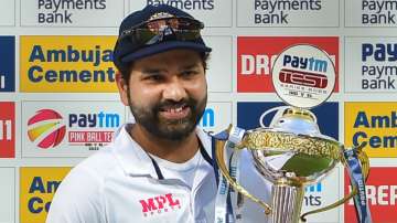 Rohit Sharma poses at the camera while lifting the trophy after India won the Test series against Sr