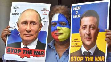 A man with his face painted with colours of the national flags of Russia and Ukraine holds portraits of Vladimir Putin and Volodymyr Zelenskyy requesting them to stop the war, in Bhopal.