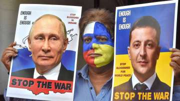 A man with his face painted with colours of the national flags of Russia and Ukraine, hold portraits of Vladimir Putin and Ukrainian Volodymyr Zelenskyy requesting them to stop the war, in Bhopal, Saturday, March 12.