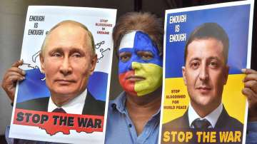 A man with his face painted with colours of the national flags of Russia and Ukraine, hold portraits of Vladimir Putin and Volodymyr Zelenskyy requesting them to stop the war, in Bhopal, March 12, 2022.