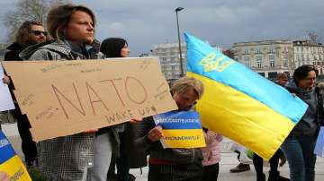 A Ukrainian woman holds a sign reading "Nato wake up" as another demonstrator holds an Ukrainian flag during a demonstration in solidarity with the Ukrainian people in Bayonne, southwestern France.