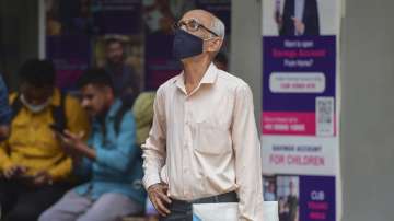 People examine the Sensex updates on a screen outside the Bombay Stock Exchange (BSE) building, as the market goes down 1700 points, in Mumbai, Monday, March 7, 2022. 