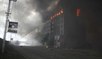 Firefighters hose down a burning building after bombing in Kyiv, Ukraine, Thursday, March 3, 2022. Russian forces have seized a strategic Ukrainian seaport and besieged another. Those moves are part of efforts to cut the country off from its coastline even as Moscow said Thursday it was ready for talks to end the fighting.