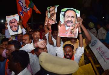 Supporters shout slogans as Karnataka RDPR Minister K S Eshwarappa arrives to submit his resignation to Karnataka Chief Minister