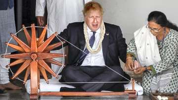 British PM Boris Johnson tries his hands on a spinning wheel during a visit to the Sabarmati Gandhi Ashram, in Ahmedabad, Thursday, April 21, 2022.