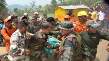 Indo-Tibetan Border Police (ITBP), National Disaster Response Force (NDRF) and Army personnel carry the body of a tourist who died after falling from the chopper, during the rescue operation after collision between two cable cars at Trikut Ropeway, in Deoghar district