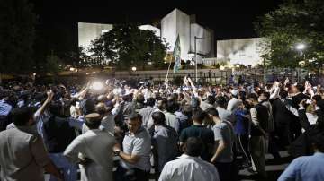 People walks past the Supreme Court where a petition hearing to dissolve parliament by country's Prime Minister took place in Islamabad, Pakistan.