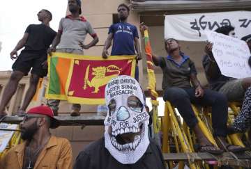 A Sri Lankan protester wears a face mask condemning the 2019 Easter Sunday attacks on the third anniversary of the attacks, protest against the country's economic crisis outside the President's office in Colombo, Sri Lanka on Thursday, April 21.