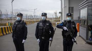 Police officers stand at the outer entrance of the Urumqi No. 3 Detention Center in Dabancheng in western China's Xinjiang Uyghur Autonomous Region