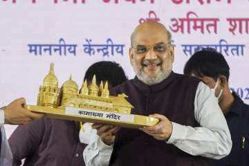 Union Home Minister Amit Shah receives miniature Kamakhya temple during the inauguration of Janaganana Bhawan at Amingaon, in Kamrup district, Monday, May 9, 2022.