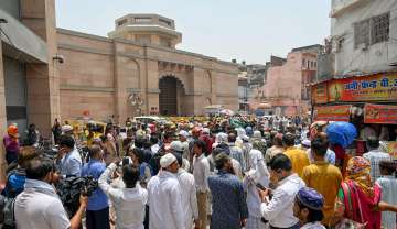 Security personnel stand guard as Muslims arrive in a large number at the Gyanvapi mosque to offer Friday prayers, in Varanasi.