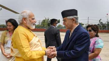 Prime Minister Narendra Modi is greeted by Nepal PM Sher Bahadur Deuba as he arrives in Lumbini, the birthplace of Lord Buddha. 