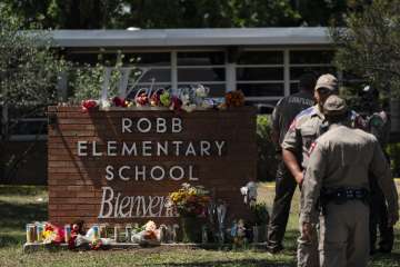 Flowers and candles are placed outside Robb Elementary School in Uvalde, Texas, Wednesday, May 25, 2022, to honor the victims killed in Tuesday's shooting at the school.