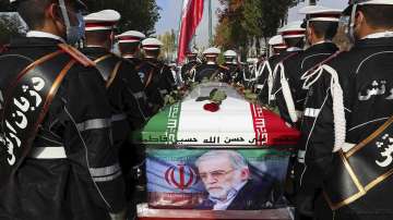 In this photo released by the official website of the Iranian Defense Ministry, military personnel stand near the flag-draped coffin of Mohsen Fakhrizadeh, a scientist who was killed on Friday, during a funeral ceremony in Tehran, Iran, Monday, Nov. 30, 2020. 