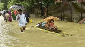 People use a banana raft to move to a safe place at a flood-hit village in Nalbari district of Assam on Saturday, June 18