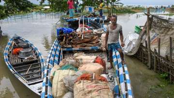Flood-affected villagers use boats to shift to safer areas after heavy rainfall, in Morigaon, Sunday, June 19, 2022.