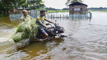Kamrup: A motorcyclist wades through a flooded road in Kamrup district of Assam on Wednesday, June 22