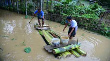 Villagers use a banana raft to cross a flooded street in Nagaon district of Assam.
