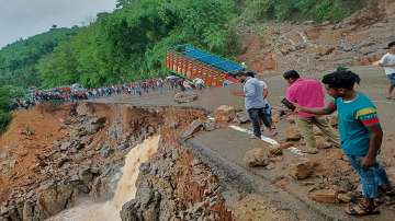 People gather near a truck after it crashed as some part of the National Highway 6 (NH06) under Lumshnong Police Stations jurisdiction caved in due to a landslide after heavy rains, in Meghalayas East Jaintia Hills district.
