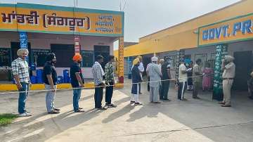 People queue up at a polling station to cast their votes for the Sangrur Lok Sabha bypolls.