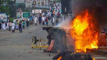 Flames and smoke rise from a vehicle on fire, that was allegedly set ablaze by miscreants during a protest in Howrah over controversial remarks made by two now-suspended BJP leaders about Prophet Mohammad.
