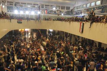 Iraqi protesters fill the Parliament building in Baghdad, Iraq, Saturday, July 30, 2022 as thousands of followers of an influential Shiite cleric breached the building for the second time in a week to protest the government formation efforts lead by Iran-backed groups.