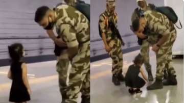 Little girl touches army personnel's feet 