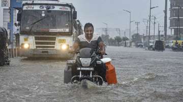 Rajkot: A man riding a motorcycle wades through the waterlogged Ring Road after monsoon rains, in Rajkot.