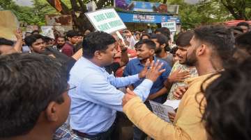 An official interacts with activists protesting against the proposed metro car shed project in Aarey forest area, in Mumbai.
