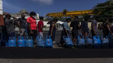 People wait in a queue with empty cylinders to buy domestic gas at a distribution center, in Colombo 
