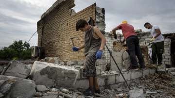 Ukraine - Danyk Rak, 12, clears rubbish on the second floor of Zhanna and Serhiy Dynaeva's house which was destroyed by Russian bombardment 