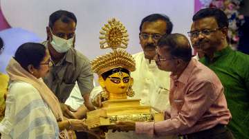 West Bengal Chief Minister Mamata Banerjee being presented a bust of Goddess Durga during a coordination meeting with the organisers of Community Durga Puja, in Kolkata, Monday, Aug. 22, 2022. 