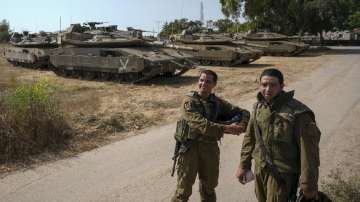 Israeli soldiers near their tanks in an area near the border with Gaza Strip, Friday, Aug. 5, 2022. 