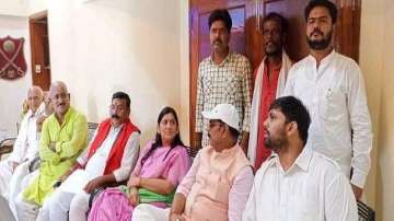 The RJD leader, in red jacket, was seen sitting with his supporters.