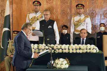 Pakistan's President Arif Alvi, center, administrates oath from newly appointed Finance Minister Ishaq Dar, left, as Prime Minister Shehbaz Sharif, right, watches during a ceremony in Islamabad, Pakistan, Wednesday, Sept. 28, 2022. 