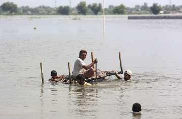 People use cots to salvage belongings from their nearby flooded homes caused by heavy rain in Jaffarabad, a district of Pakistan's southwestern Baluchistan province