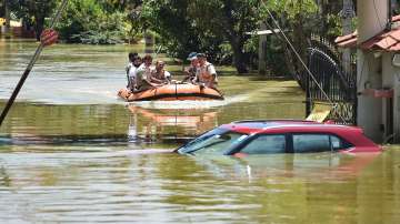 Fire fighters while evacuating residents from flooded Rainbow Drive Layout locality after heavy monsoon rains at Sarjapur, in Bengaluru, Monday.