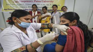 A healthcare worker administers a dose of Covid-19 preventive vaccine to a student. 