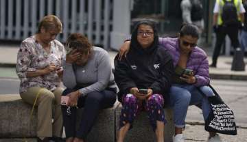 People gather outside after a magnitude 7.6 earthquake was felt in Mexico City, Monday, Sept. 19, 2022. 