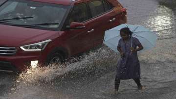 A passing car splashes water on a girl walking in the rain in Hyderabad, India, Wednesday, Sept. 7, 2022.