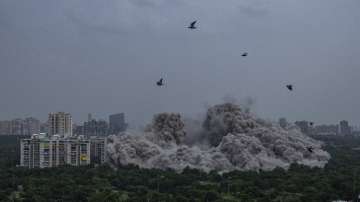 Clouds of dust rise as twin high-rise apartment towers are leveled in a controlled demolition in Noida, on the outskirts of New Delhi, India, Sunday, Aug. 28, 2022.