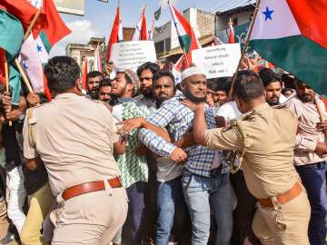 Police attempt to detain Popular Front of India (PFI) and Social Democratic Party of India (SDPI) workers during a protest against the raid of National Investigation Agency (NIA).