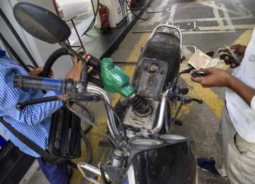 A pump attendant fills petrol in a bike at a fuel station in New Delhi. 