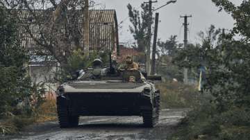 A Ukrainian military vehicle moves on the road in the freed territory in the Kharkiv region, Ukraine, Monday, Sept. 12, 2022. 